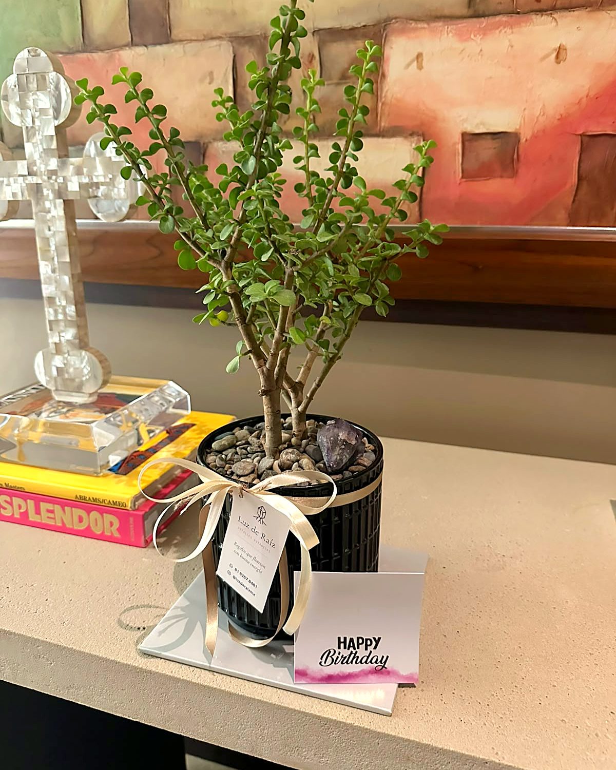 Árbol de la abundancia con amatista, moño y tarjeta de cumpleaños sobre una consola